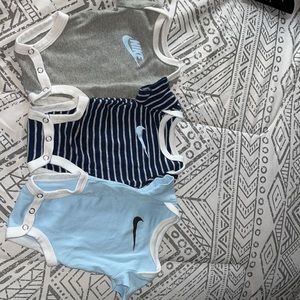 3 newborn Nike onsies
